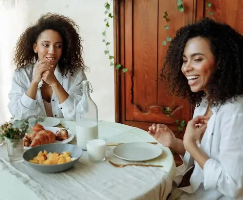 Two women sitting at table with food